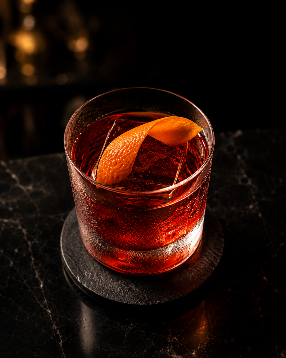 Negroni over a clear ice cube with orange peel